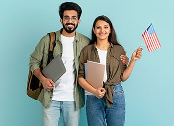 Couple celebrating visa approval with legal documentation and the U.S. flag in hand - Aminu Law Firm, PLLC