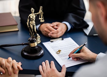 Legal agreement process with a gavel and justice scales symbolizing the law - Aminu Law Firm, PLLC