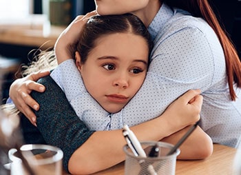 Woman and girl sharing a hug, symbolizing non-custodial parent visitation - Aminu Law Firm, PLLC