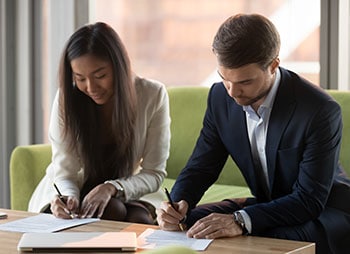 Couple signing the divorce papers - Aminu Law Firm, PLLC