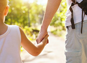 Child walking with parent during a custody agreement transition - Aminu Law Firm, PLLC